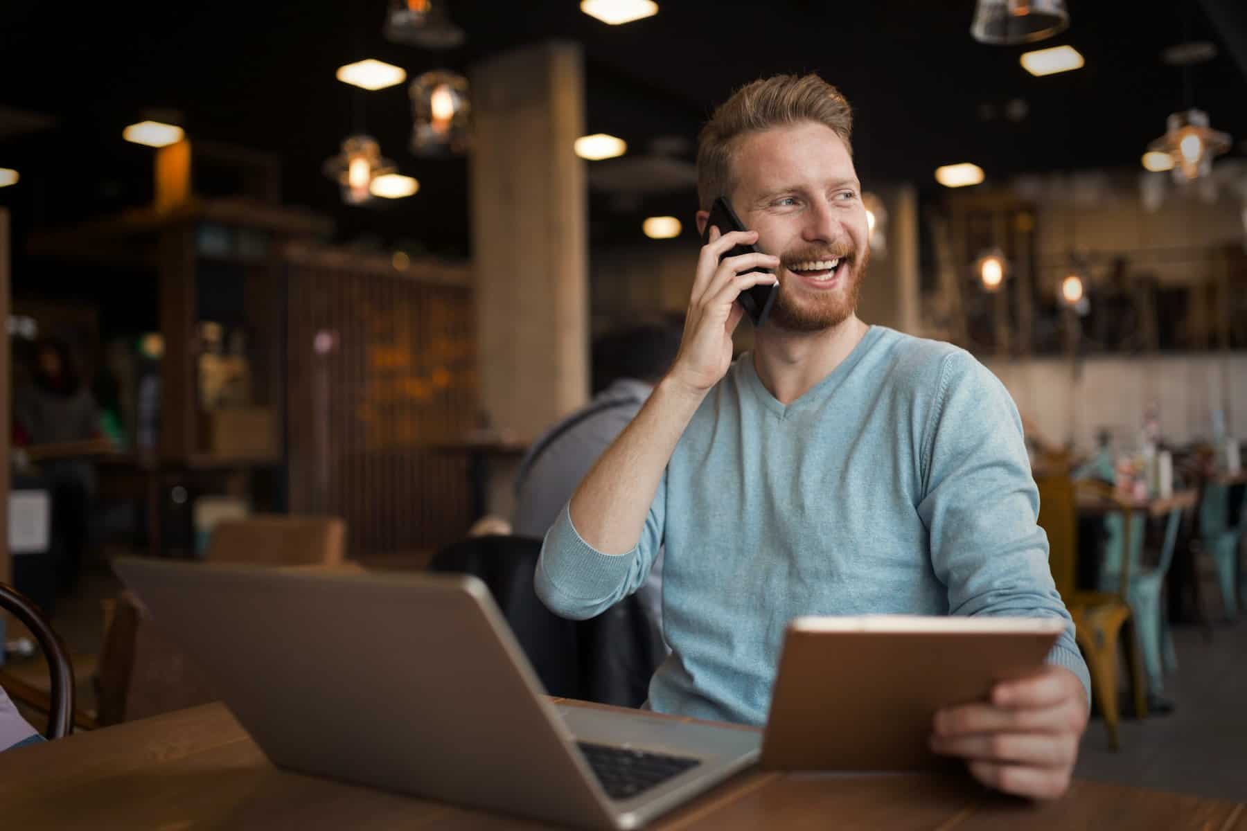Happy man on phone receiving news about a job offer.